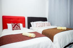 two beds in a room with white and red at I-city Sweet in Shah Alam