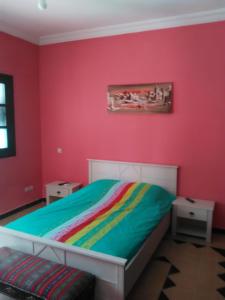 馬拉喀什的住宿－Riad Marrakech Ourika，卧室设有红色的墙壁和彩虹床