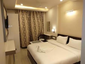 a hotel room with a bed and a television at Hotel Varanasi Heritage in Varanasi