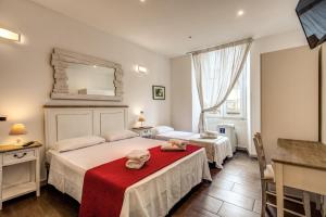 ローマにあるMagenta Collection Del Grande 51のベッド2台と鏡が備わるホテルルームです。