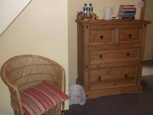 a bedroom with a dresser and a chair with a pillow at Stepping Stone Bed and Breakfast in Glencar