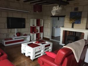 Villebernierにあるmaison de loireのリビングルーム(赤いソファ、暖炉付)