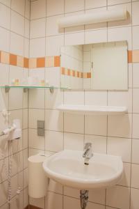 een witte badkamer met een wastafel en een spiegel bij Haus Grillensee in Naunhof