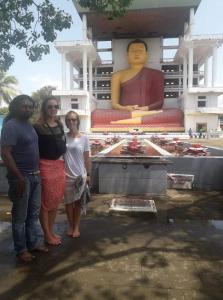 un grupo de personas de pie frente a una estatua en Sunset Surfing Beach Resort, en Matara