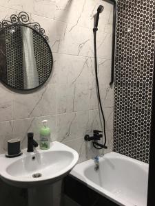 ウラジカフカスにあるОднокомнатная-двухуровневая квартираのバスルーム(洗面台、バスタブの横にシャワー付)