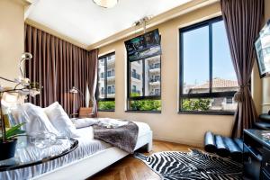 a living room with a bed and two windows at Montefiore 16 - Urban Boutique Hotel in Tel Aviv