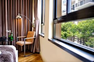 a room with a window with a chair and a table at Montefiore 16 - Urban Boutique Hotel in Tel Aviv