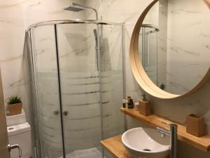 uma casa de banho com um chuveiro, um lavatório e um espelho. em Flight Apartments Airport by Airstay em Spata