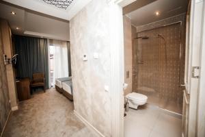 a bathroom with a shower, toilet and sink at Grand Hotel Mimino in Tbilisi City
