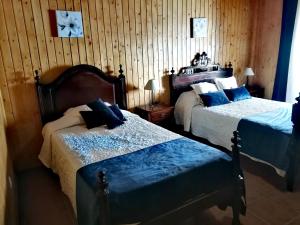 a bedroom with two beds and a clock on the wall at Casa do Castelo in Arraiolos