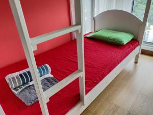 a bedroom with a bunk bed with red sheets and a red blanket at SkyBed Over The Sky Hostel @Regalia Suites & Residences KL in Kuala Lumpur