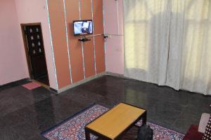 a room with a table and a tv on a wall at Feel Like Home in Visakhapatnam