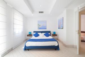 una camera da letto con un letto blu e bianco con cuscini blu di Villa Le Tore a Sorrento