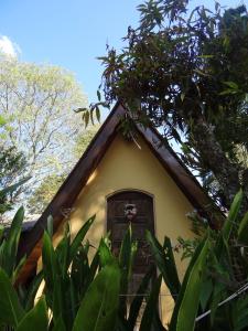 a small house with a thatched roof at Chalé Rancho Aratama in Jacareí