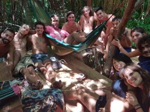 a group of people sitting around in a hammock at Lagarto Na Banana Hostel in Pipa