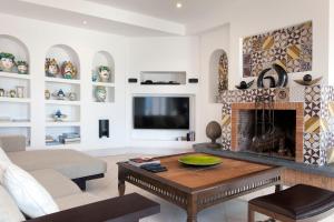 ein Wohnzimmer mit einem Kamin und einem TV in der Unterkunft Villa Le Tore in Sorrent