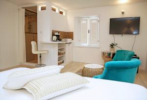 シベニクにあるSwan City Apartment & Roomのベッド1台、椅子2脚、テレビが備わる客室です。