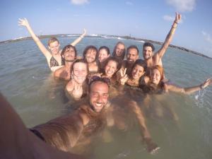 a group of people swimming in the water at Lagarto Na Banana Hostel in Pipa