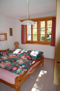 een slaapkamer met een bed met een kleurrijk dekbed bij Londadusa Parterre in Rueras