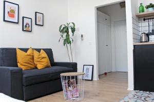 ein Wohnzimmer mit einem blauen Sofa und gelben Kissen in der Unterkunft Studio apartman Trešnjevka in Zagreb