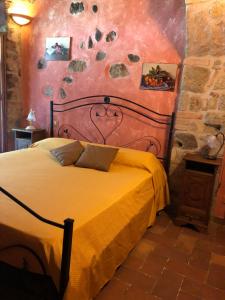 a bedroom with a large bed with a yellow blanket at Podere Mazzarelle in Castel del Piano