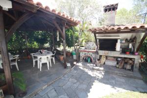 an outdoor patio with a fireplace and a table at Villa Angela in Vourvourou