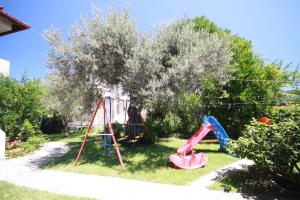 a yard with a swing set and a playground at Villa Angela in Vourvourou