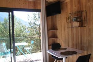 a room with a table and a window with a view at Clos Shambhala-Chalet d'hôtes in Saint-Jean-Saint-Nicolas
