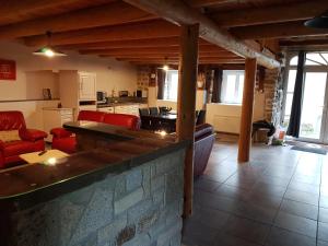 eine Küche und ein Wohnzimmer mit roten Möbeln in einem Haus in der Unterkunft " gite Au Pied Du Chapelas" in Le Plagnal