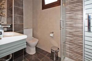 a bathroom with a toilet and a sink and a shower at Villa Angela in Vourvourou