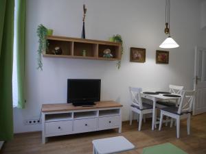 a living room with a table and a television on a cabinet at Moskevská 40 in Karlovy Vary