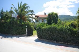 a house with a hedge in front of a street at Villa Angela in Vourvourou