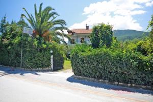 a house with a hedge in front of a street at Villa Angela in Vourvourou