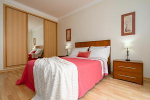 una camera da letto con un grande letto con una coperta rossa di Cozy Apartment PORTIMÃO City Center a Portimão