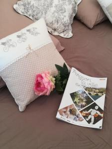 un livre et un magazine sur un lit avec une rose dans l'établissement Studio Centre-Historique, à deux pas du Palais, Wifi, à Avignon
