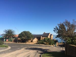 eine leere Straße mit Häusern und einem Stoppschild in der Unterkunft 14 Chapman Avenue Flat with ocean view in Gordonʼs Bay