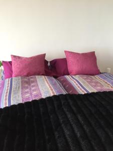 een slaapkamer met 2 bedden met paarse kussens bij 14 Chapman Avenue Flat with ocean view in Gordonsbaai