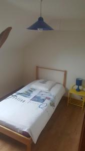 a bedroom with a bed with a white comforter at Au coeur des Volcans d'Auvergne in Ceyssat