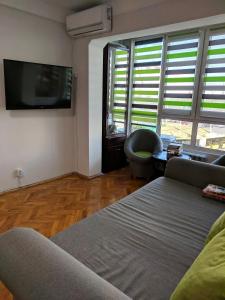 ein Wohnzimmer mit einem Sofa und einem Flachbild-TV in der Unterkunft Dream Town Apartment in Kiew