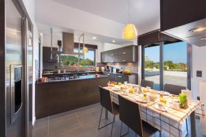 a large kitchen with a long table with chairs at Filerimos Garden Villa in Ialyssos