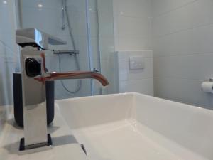 a bathroom with a sink with a faucet at B&B Het Rijkzicht in Groesbeek +23 photos