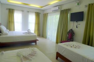 Habitación de hotel con 2 camas y TV en Greenspace Palawan en Puerto Princesa