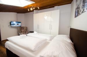 duas camas num quarto com uma televisão na parede em Penthouse EightyOne by All in One Apartments em Kaprun