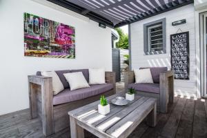 a patio with two couches and a table at Villa Chouchou - unique private pool in Orient Bay