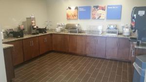 a kitchen with wooden cabinets and a counter top at Comfort Inn White House in White House +8 photos