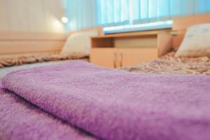 Cama púrpura en habitación con manta púrpura en Vishnya Hostel, en Dnipro