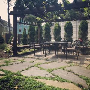 a patio with a table and chairs under a pergola at East Side Private Apartment in Providence