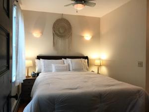 a bedroom with a bed with white pillows and a ceiling fan at East Side Private Apartment in Providence