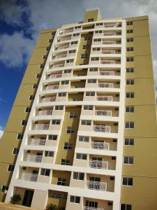 a tall yellow apartment building at Apartamento Palmas in Palmas