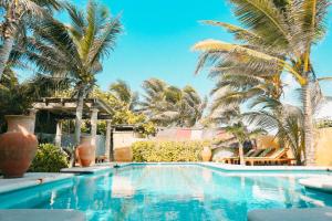 een zwembad met palmbomen op de achtergrond bij Zamas Hotel in Tulum